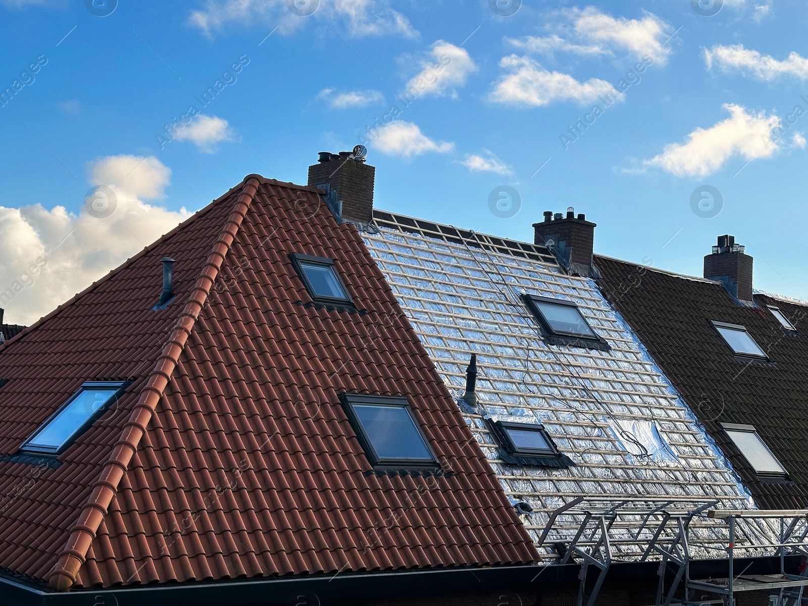 Residential building with roof renovation under blue sky Photo of Residential building with roof renovation under blue sky