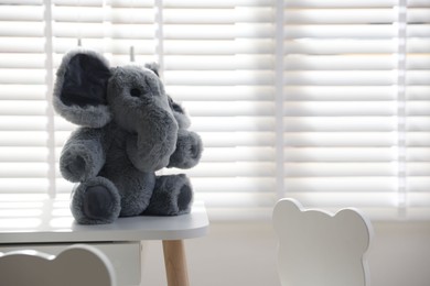 Cute elephant on table in child's room. Space for text