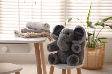 Toy elephant and blankets at table in child's room