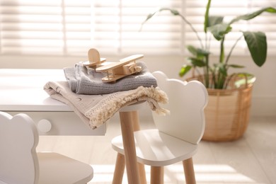 Toy plane and blankets on table in child's room