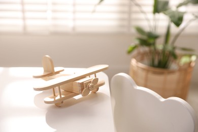 Photo of Toy plane on table in child's room. Space for text