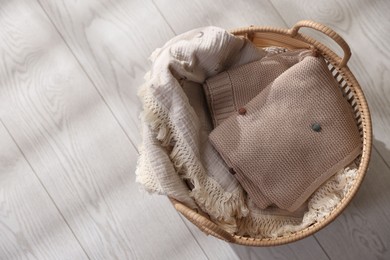 Baby blankets in basket on floor, top view. Space for text