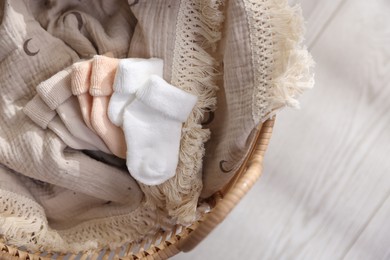 Different baby accessories in basket on floor, top view