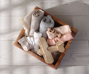 Photo of Different baby accessories in basket on floor, top view