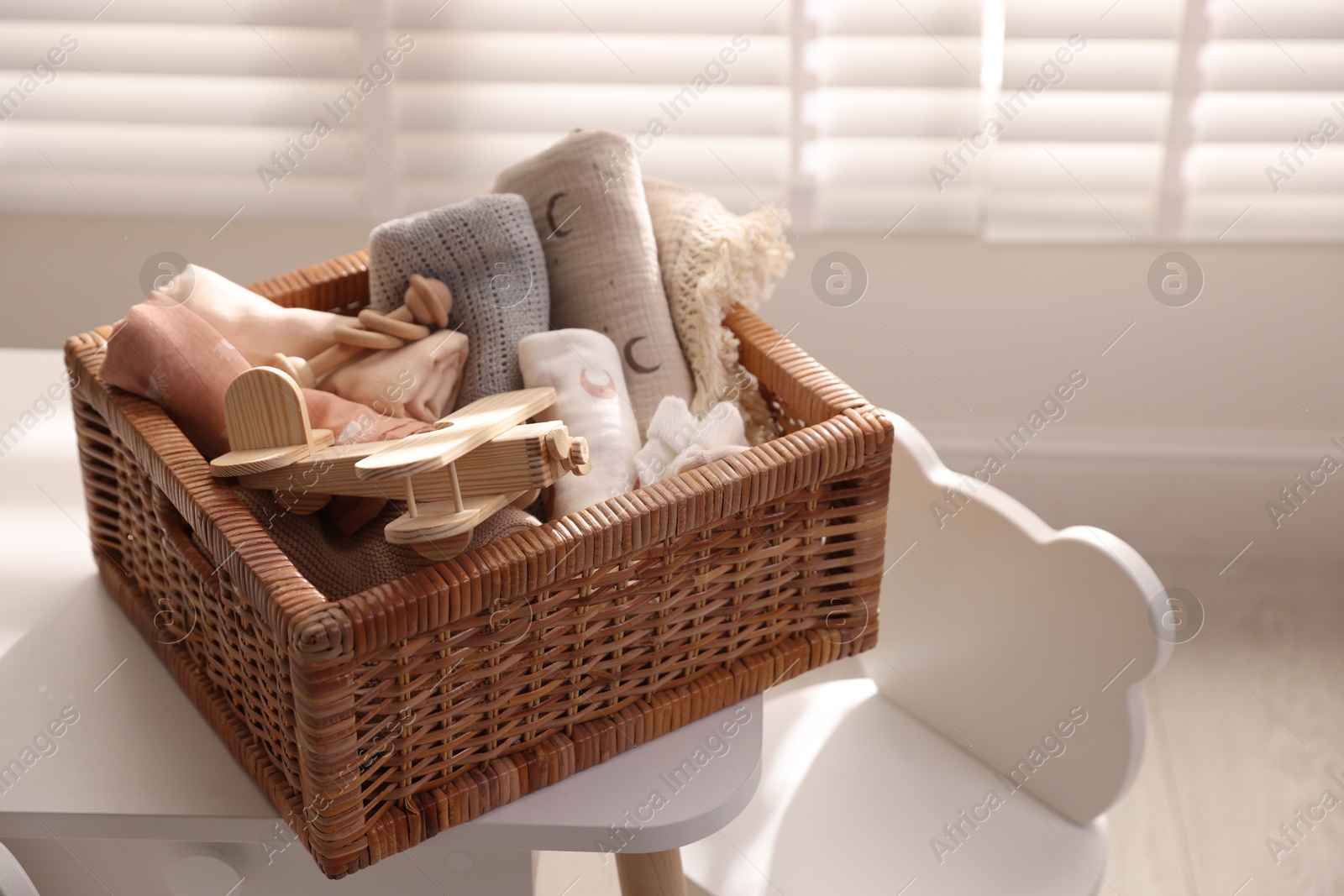 Photo of Different baby accessories in basket on table indoors