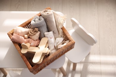 Different baby accessories in basket on table indoors