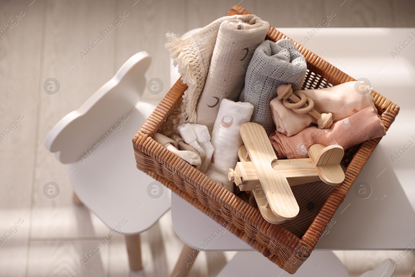 Photo of Different baby accessories in basket on table indoors