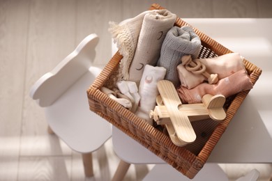 Different baby accessories in basket on table indoors