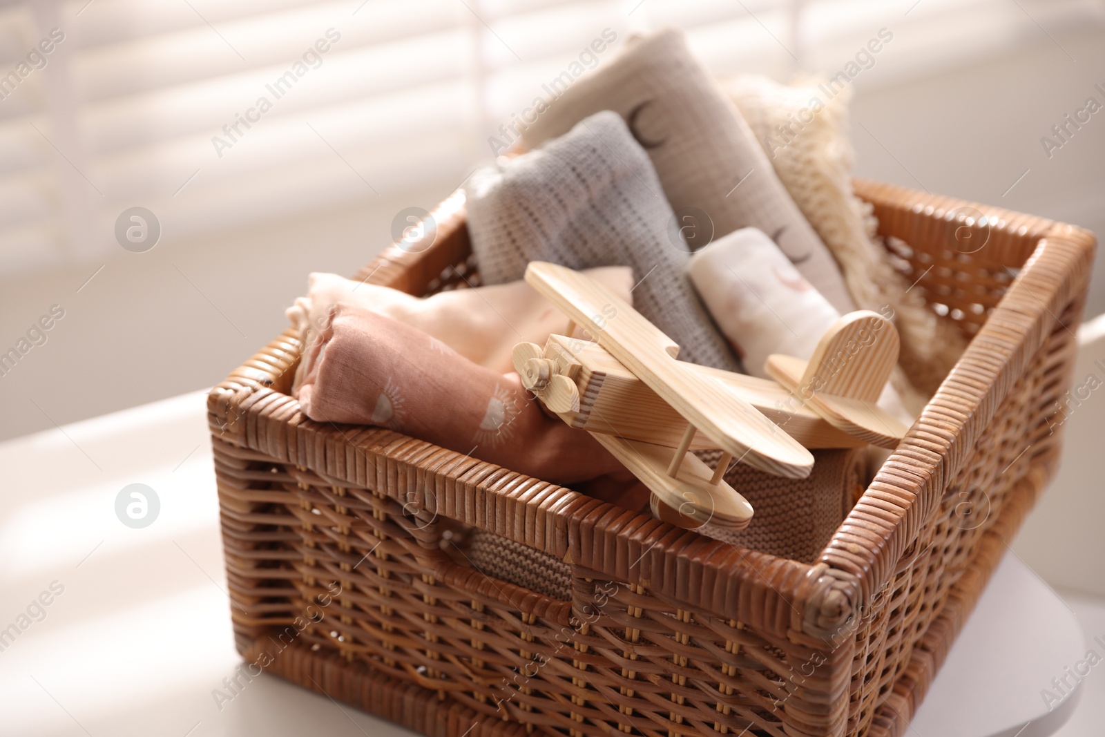 Photo of Different baby accessories in basket on table indoors, closeup