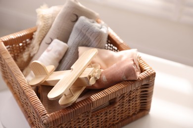 Photo of Different baby accessories in basket on table indoors, closeup