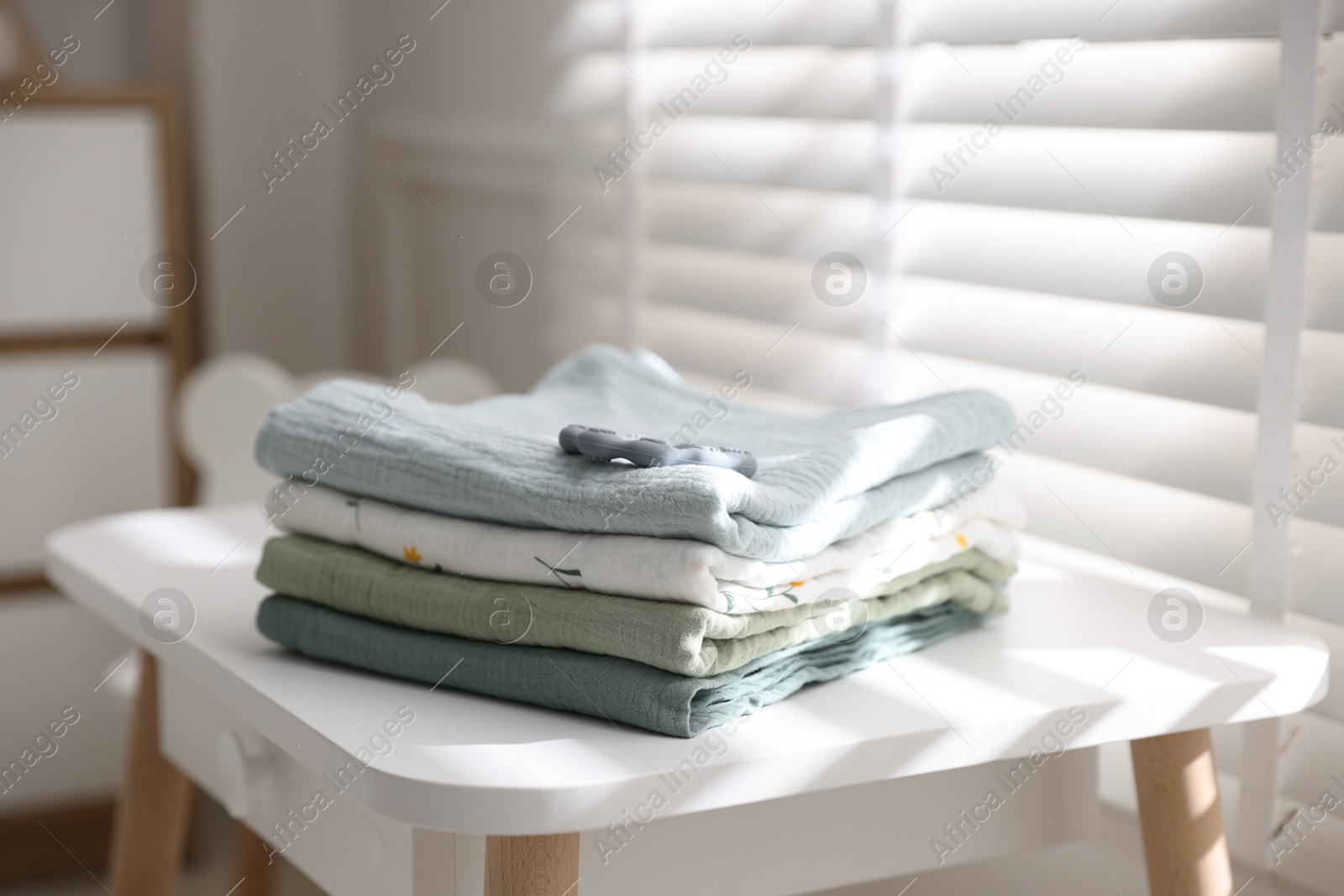 Photo of Baby swaddles and teether on table indoors