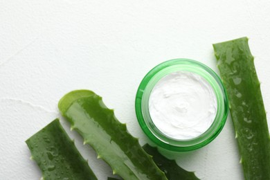 Cream and aloe leaves on white textured background, flat lay. Space for text