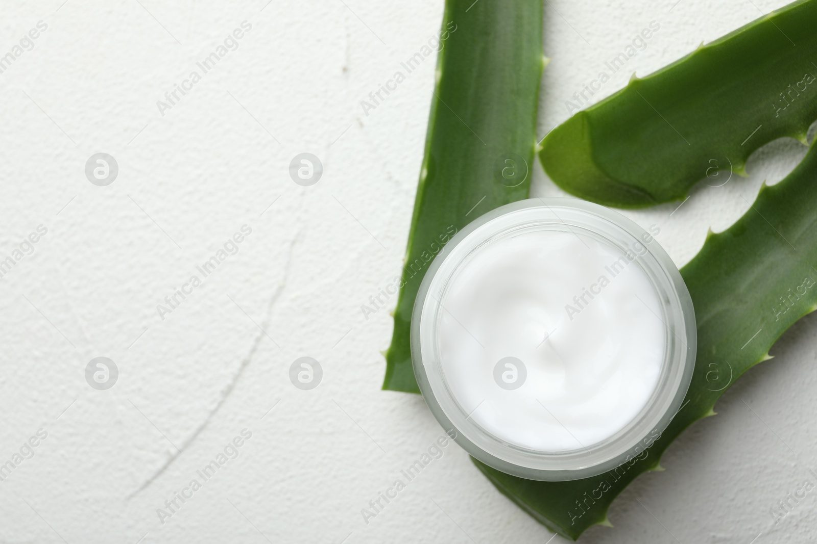 Photo of Cream and aloe leaves on white textured background, flat lay. Space for text