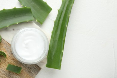 Cream and aloe leaves on white textured background, flat lay. Space for text