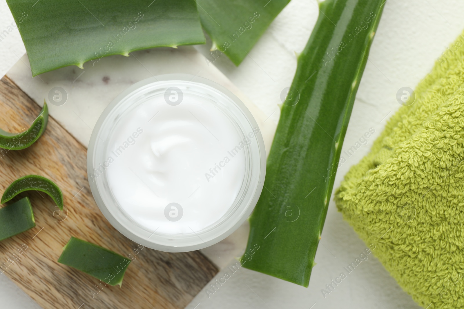 Photo of Cream and aloe leaves on white textured background, flat lay