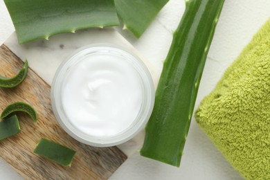 Photo of Cream and aloe leaves on white textured background, flat lay