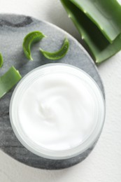 Photo of Cream and aloe leaves on white background, flat lay