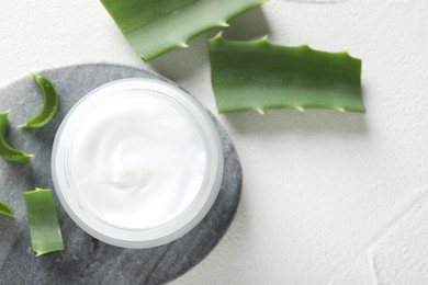 Photo of Cream and aloe leaves on white textured background, flat lay