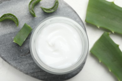 Photo of Cream and aloe leaves on white textured background, flat lay