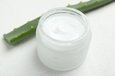 Cream and aloe leaves on white textured background, closeup