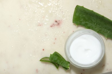 Photo of Cream and aloe leaves on light background, flat lay. Space for text