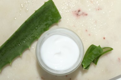 Cream and aloe leaves on light background, flat lay