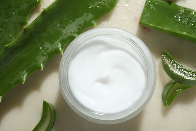 Cream and aloe leaves on light background, flat lay