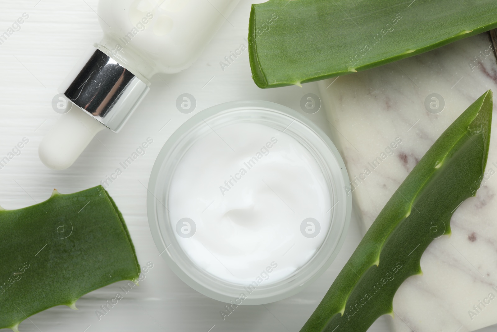 Photo of Cosmetic products and aloe leaves on white wooden background, flat lay