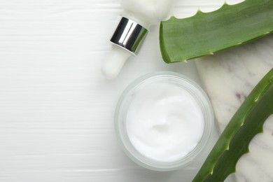 Photo of Cosmetic products and aloe leaves on white wooden background, flat lay. Space for text