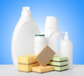 Image of Eco-friendly cleaning products on white table against light blue gradient background