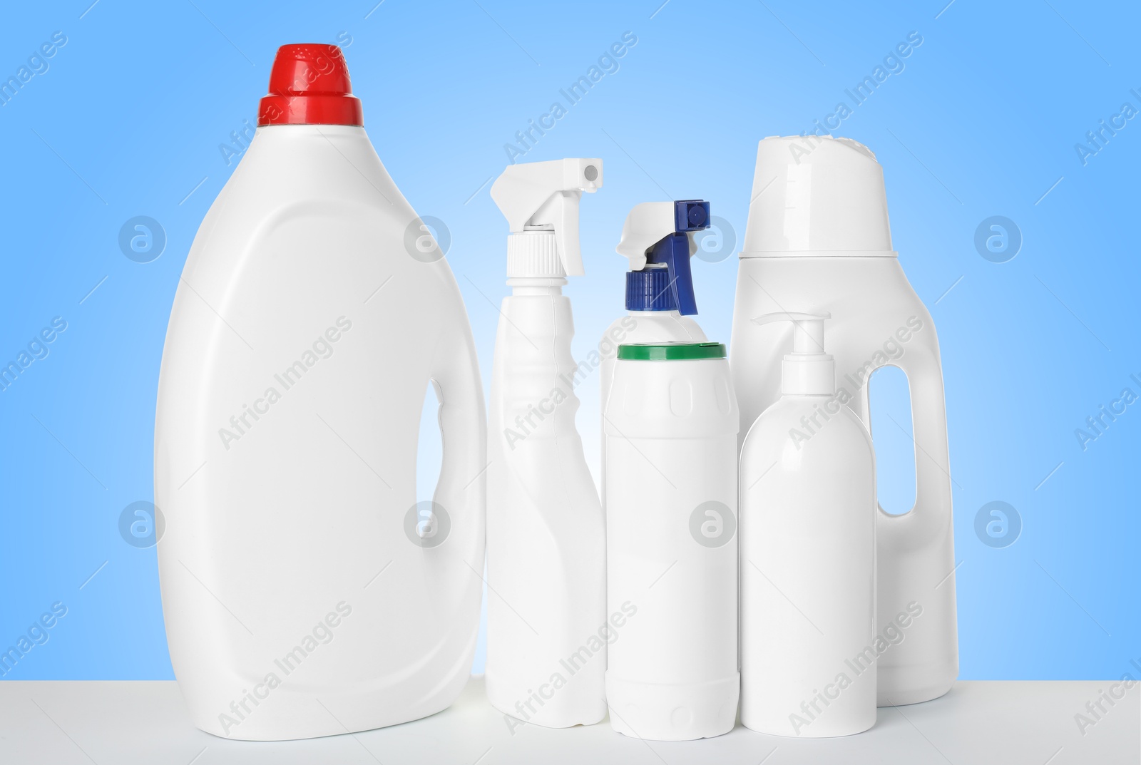 Image of Bottles of cleaning products on white table against light blue gradient background