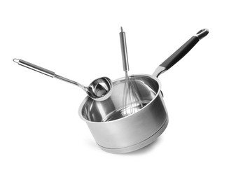 Image of Saucepan, ladle and whisk in air on white background