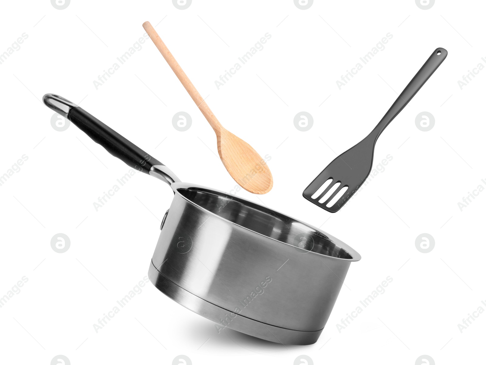 Image of Saucepan, slotted spatula and wooden spoon in air on white background