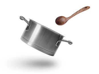 Image of Saucepan and wooden ladle in air on white background