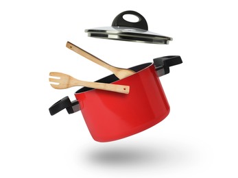 Image of Saucepan, wooden spoon and turner in air on white background