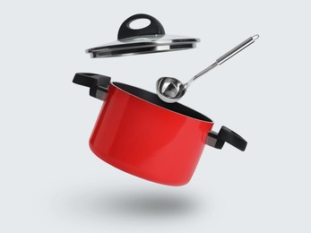 Image of Saucepan and ladle in air on white background