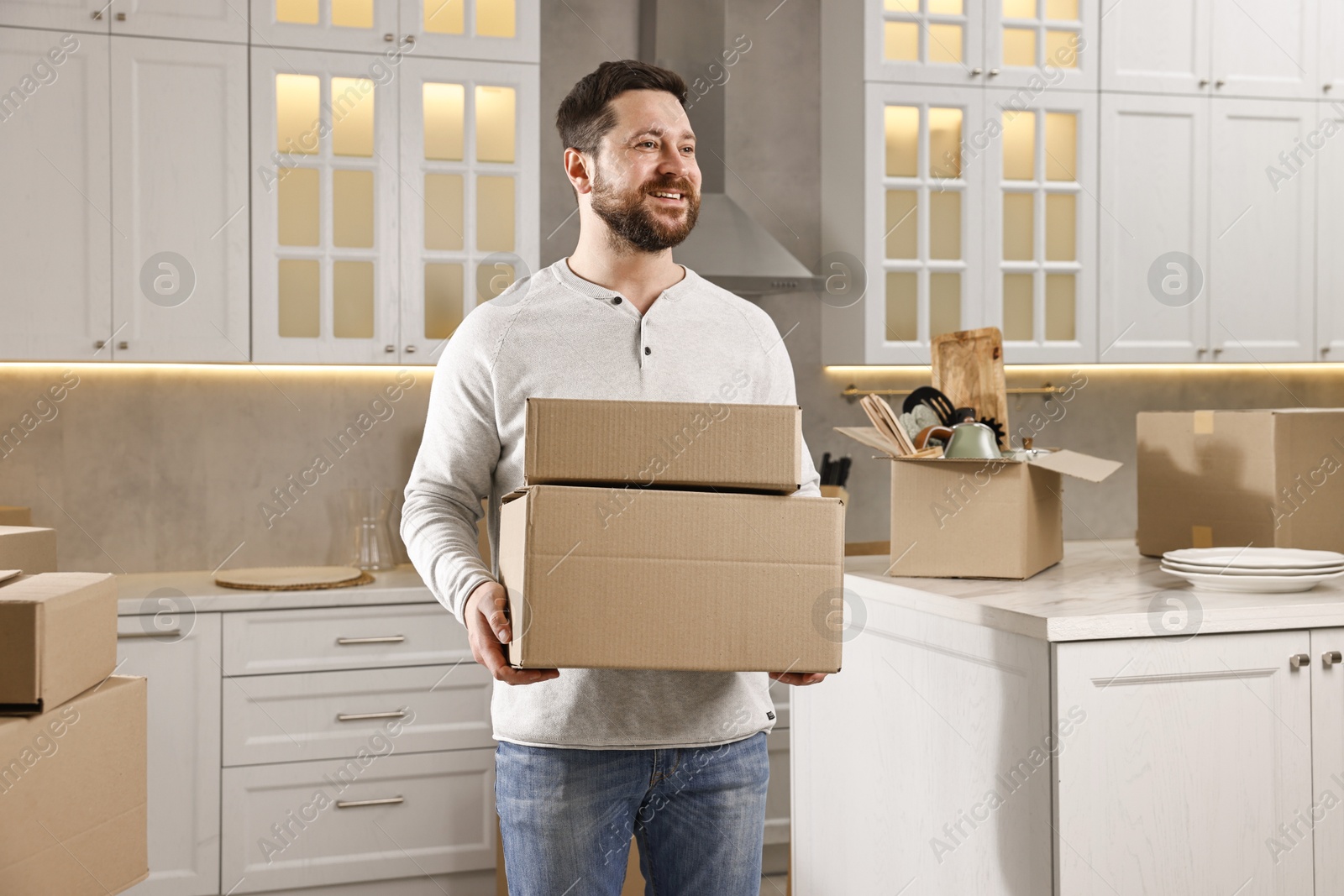 Photo of Moving day. Man with cardboard boxes in his new home