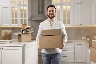 Moving day. Man with cardboard boxes in his new home