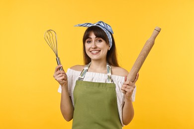 Woman with rolling pin and whisk on yellow background