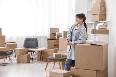 Moving day. Happy woman with her belongings in new home