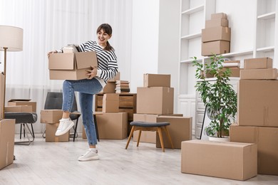 Moving day. Happy woman with her belongings in new home