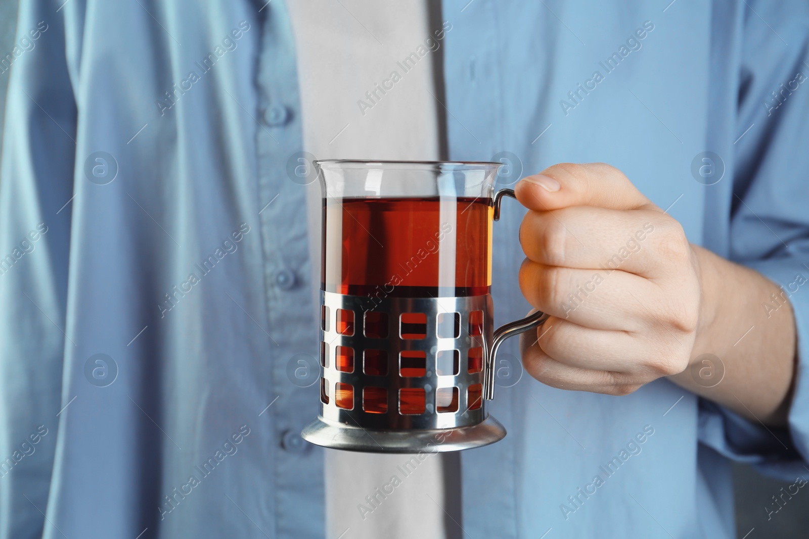 Photo of Woman with glass of tea in metal holder, closeup