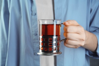 Photo of Woman with glass of tea in metal holder, closeup