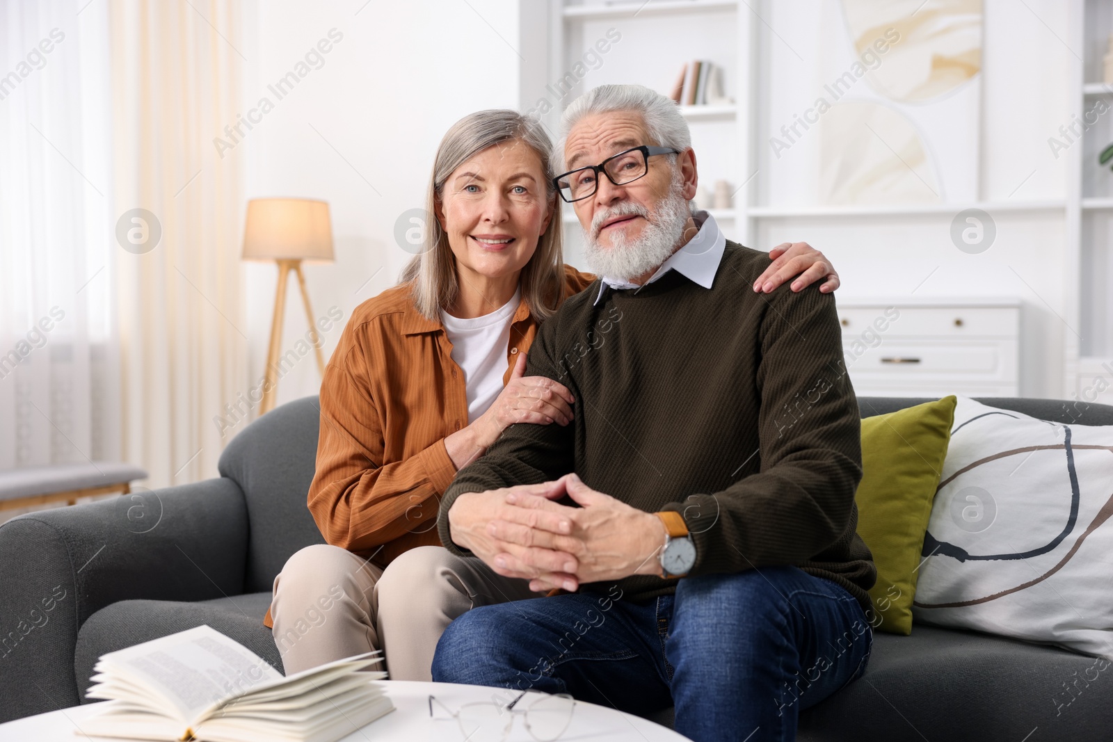 Photo of Portrait of happy elderly couple on sofa at home