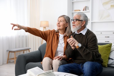 Photo of Happy elderly couple on sofa at home