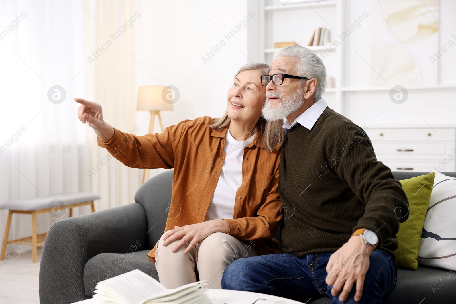 Photo of Happy elderly couple on sofa at home