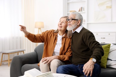 Happy elderly couple on sofa at home