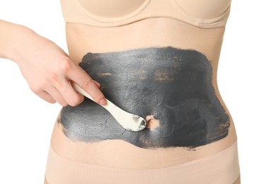 Photo of Woman applying cosmetic product for spa body wraps onto her belly against white background, closeup