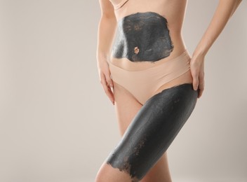 Photo of Woman doing spa body wraps on light grey background, closeup