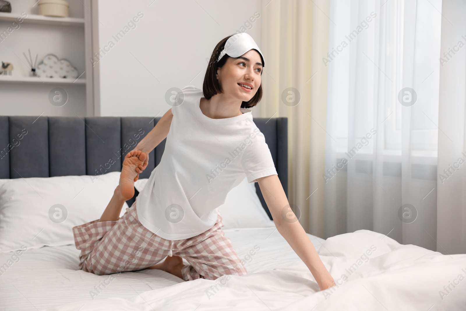 Photo of Young woman exercising on bed at home. Morning routine